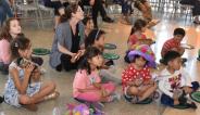 Children gathered on lily pad rugs, listening to a story.