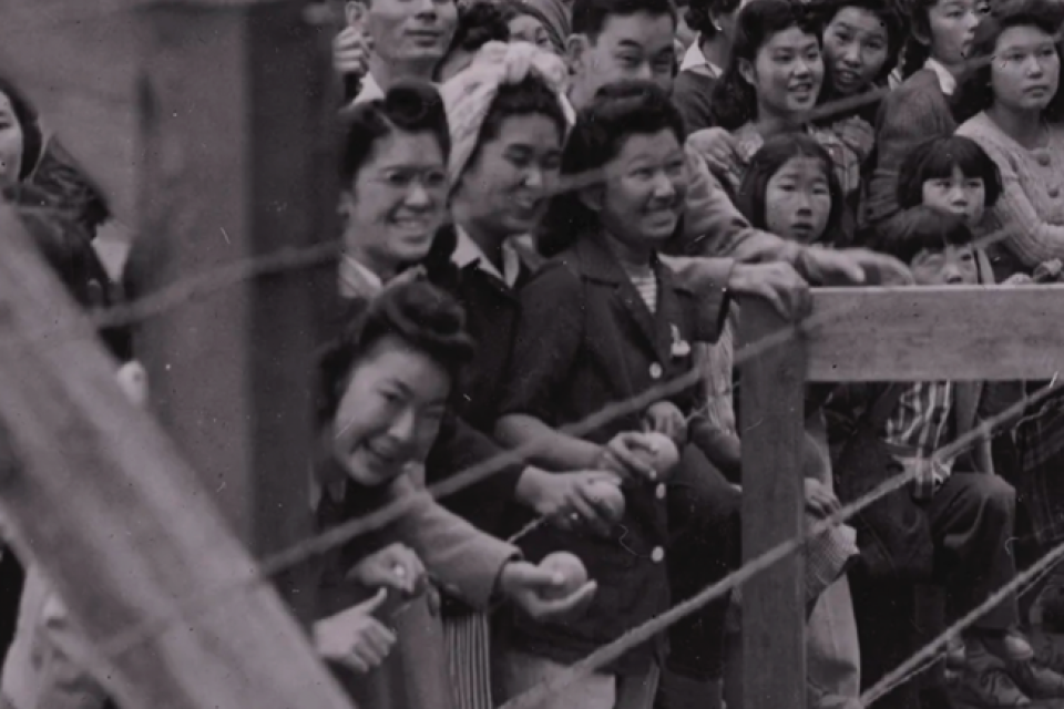incarcerees behind barbed wire in camps