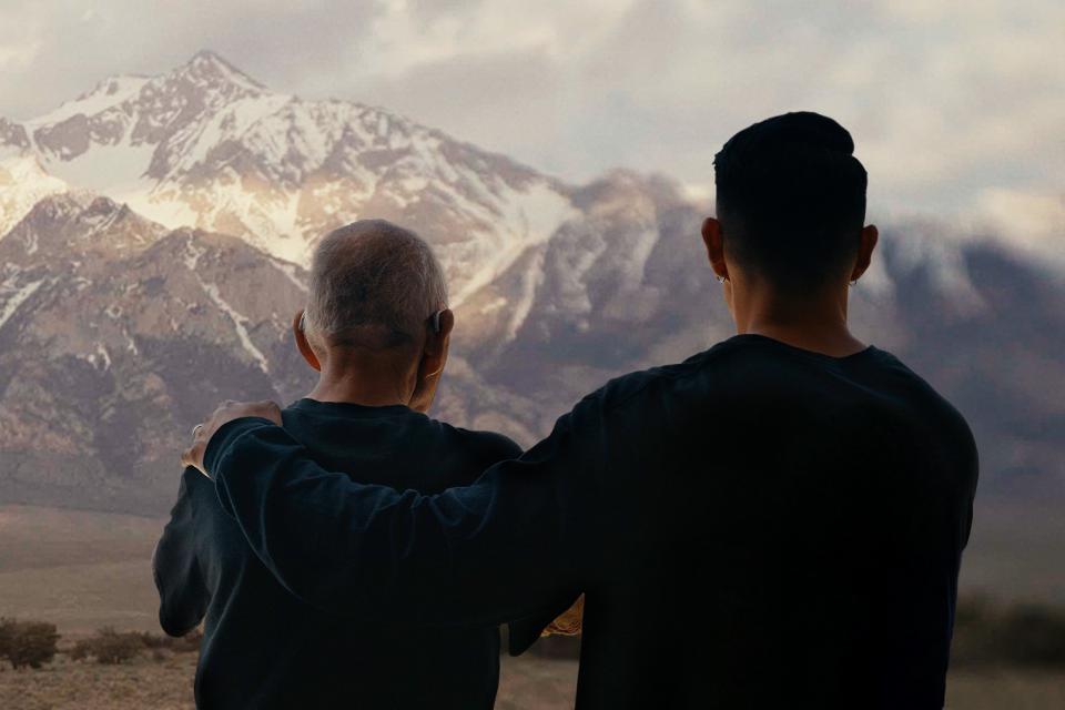 Robert Nakamura and son Tadashi Nakamura looking at snow capped mountains behind Manzanar