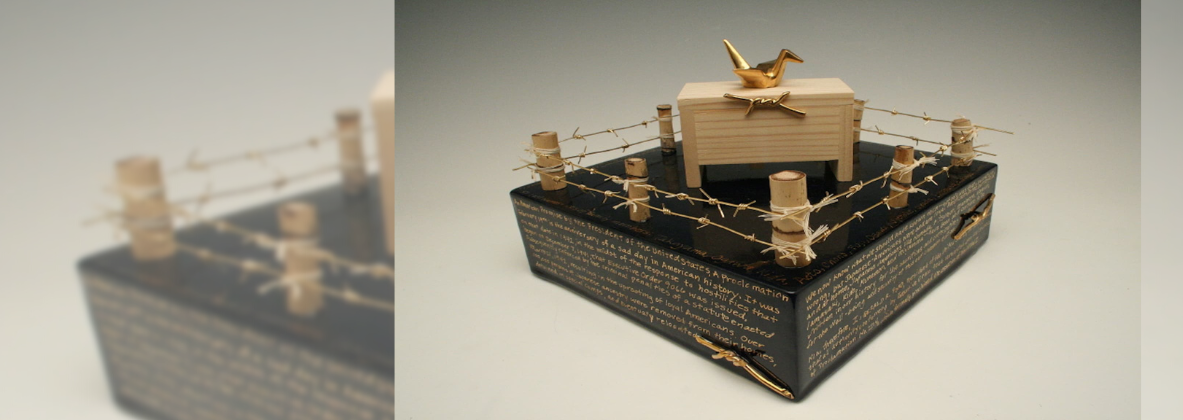 A ceramic art piece featuring imagery of barbed wire and a golden "tsuru".