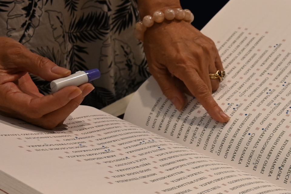 hand pointing at a name in the book of names