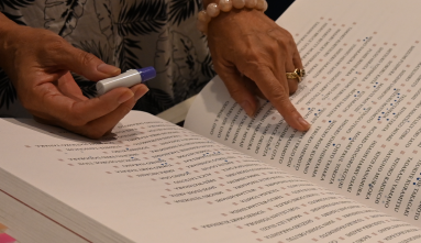 hand pointing at a name in the book of names